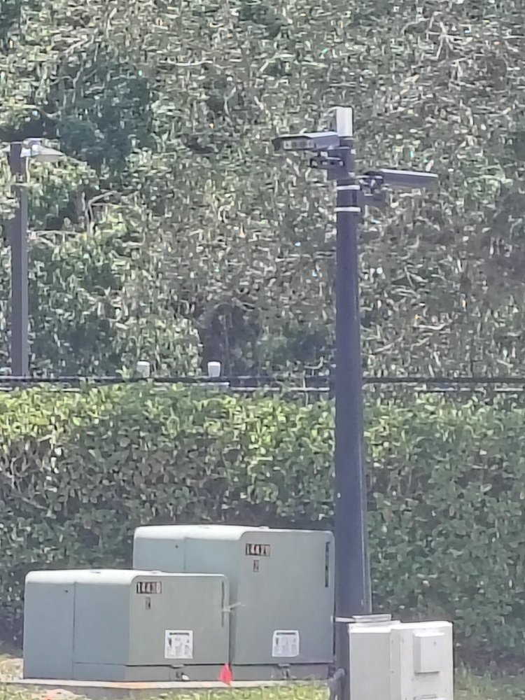 Security cameras on a pole above switchgear cabinets at the site perimeter